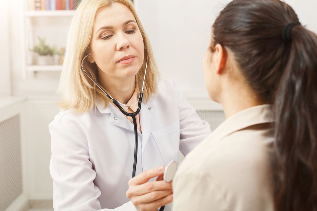 Female doctor checking heartrate of female patient
